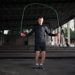 athlete doing jump rope with dark background
